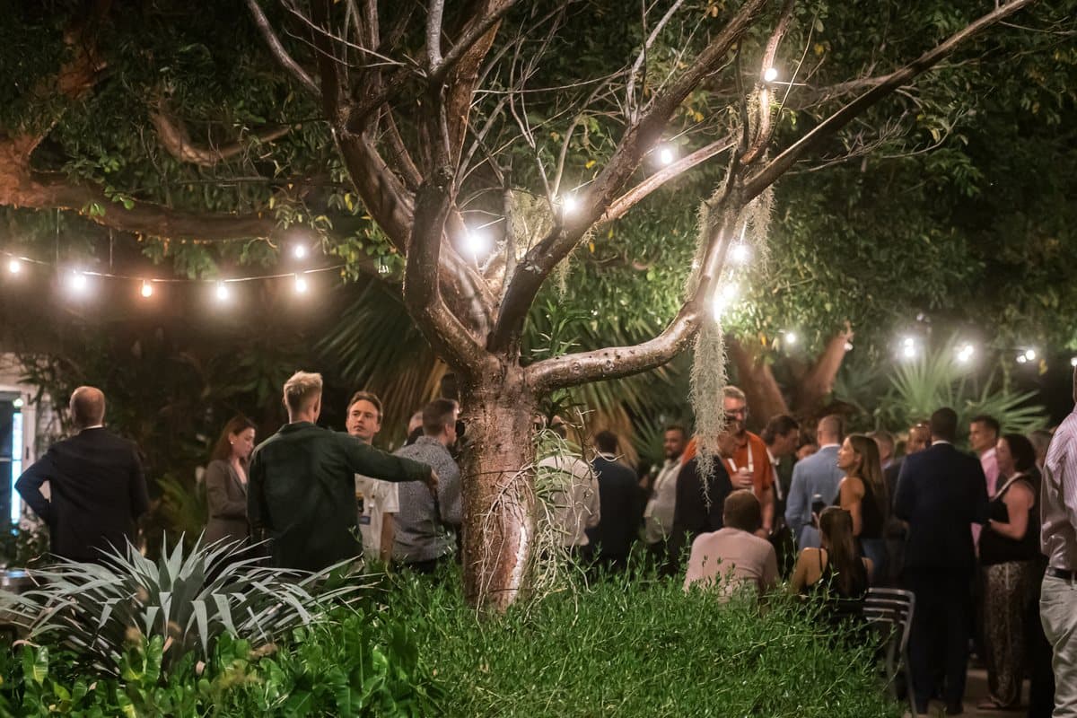 An evening reception under string lights in a garden at the Air Cargo Forum