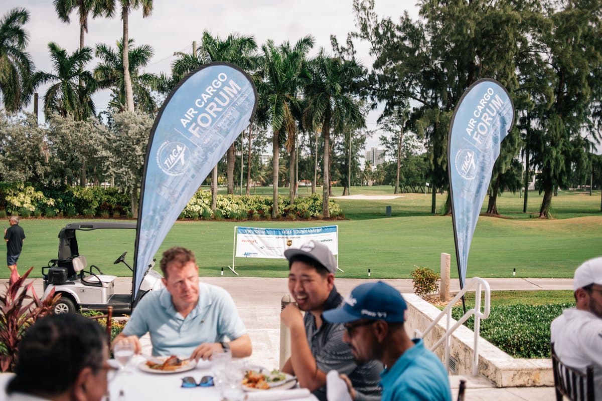 Delegates at breakfast beside Air Cargo Forum flags before the golf tournament in Miami