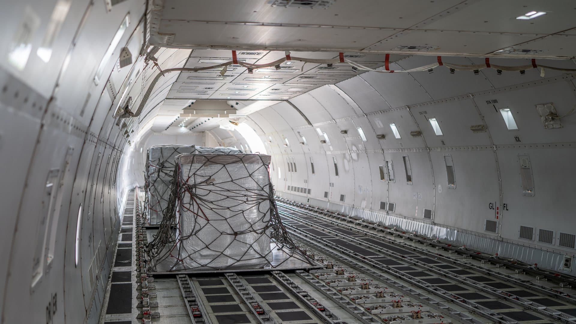 A unit load device secured on the main deck of a freighter aircraft
