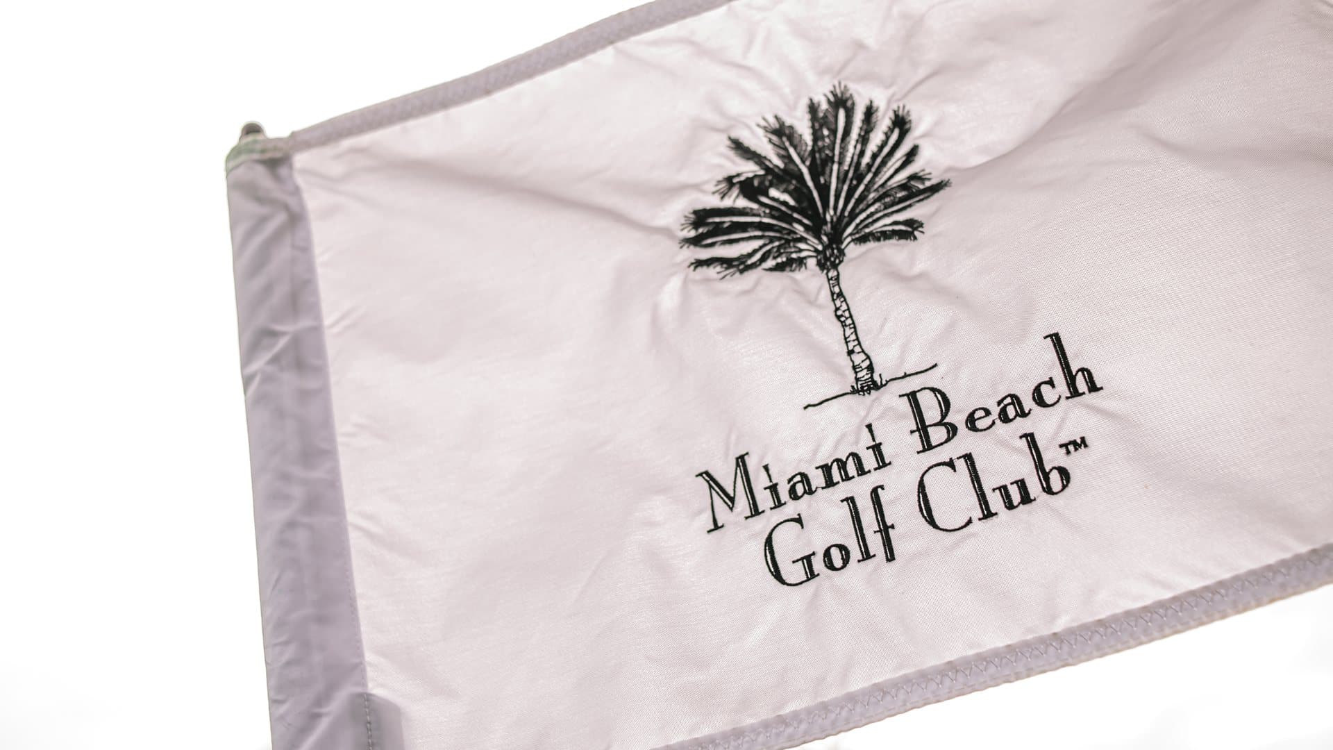 A Miami Beach Golf Club flag against a clear sky at the Air Cargo Forum golf tournament